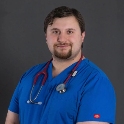 Close-up portrait of Dr. Kenneth Winebaugh in blue scrubs with a stethoscope